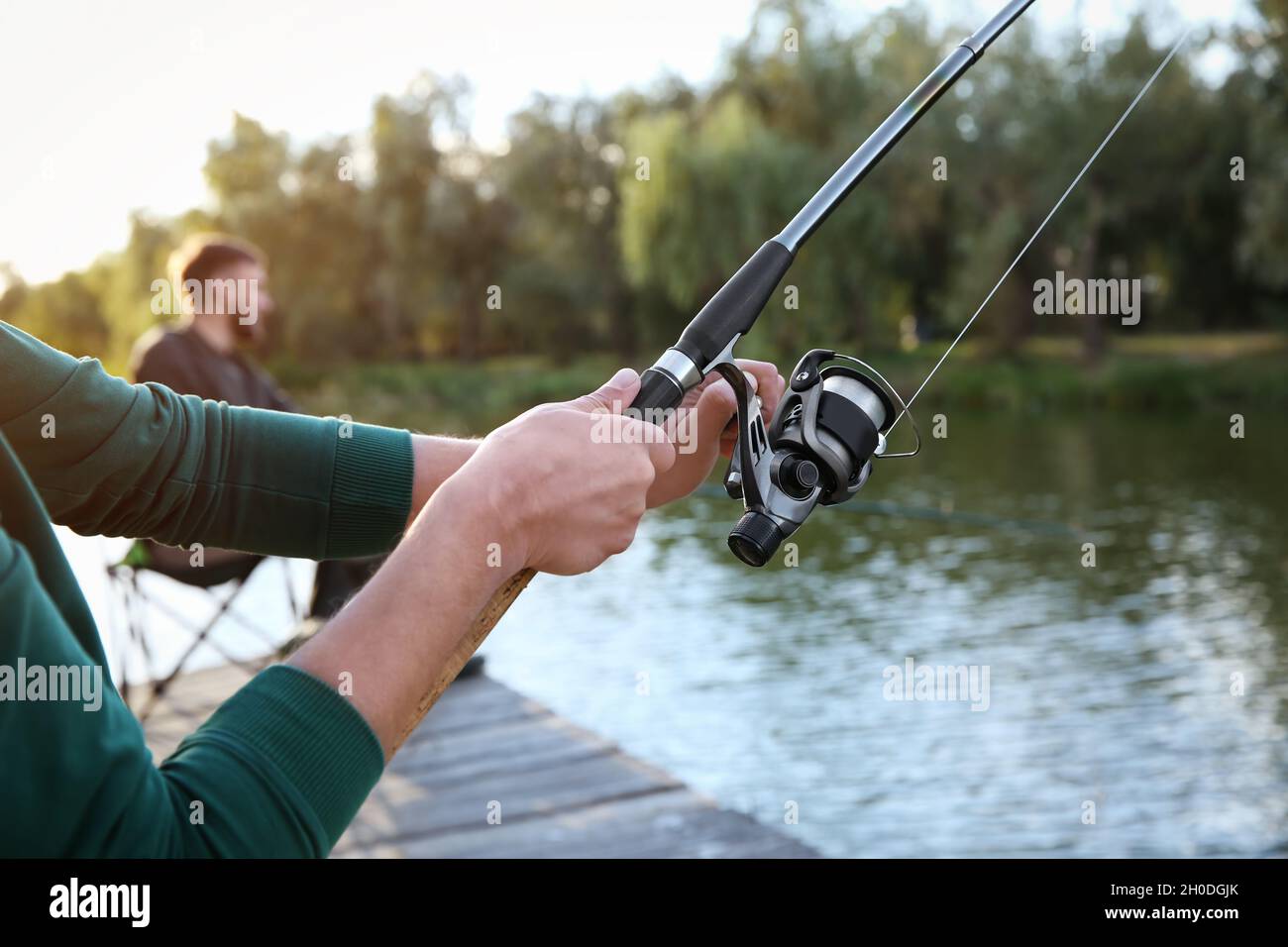 Man with rod fishing at riverside. Recreational activity Stock