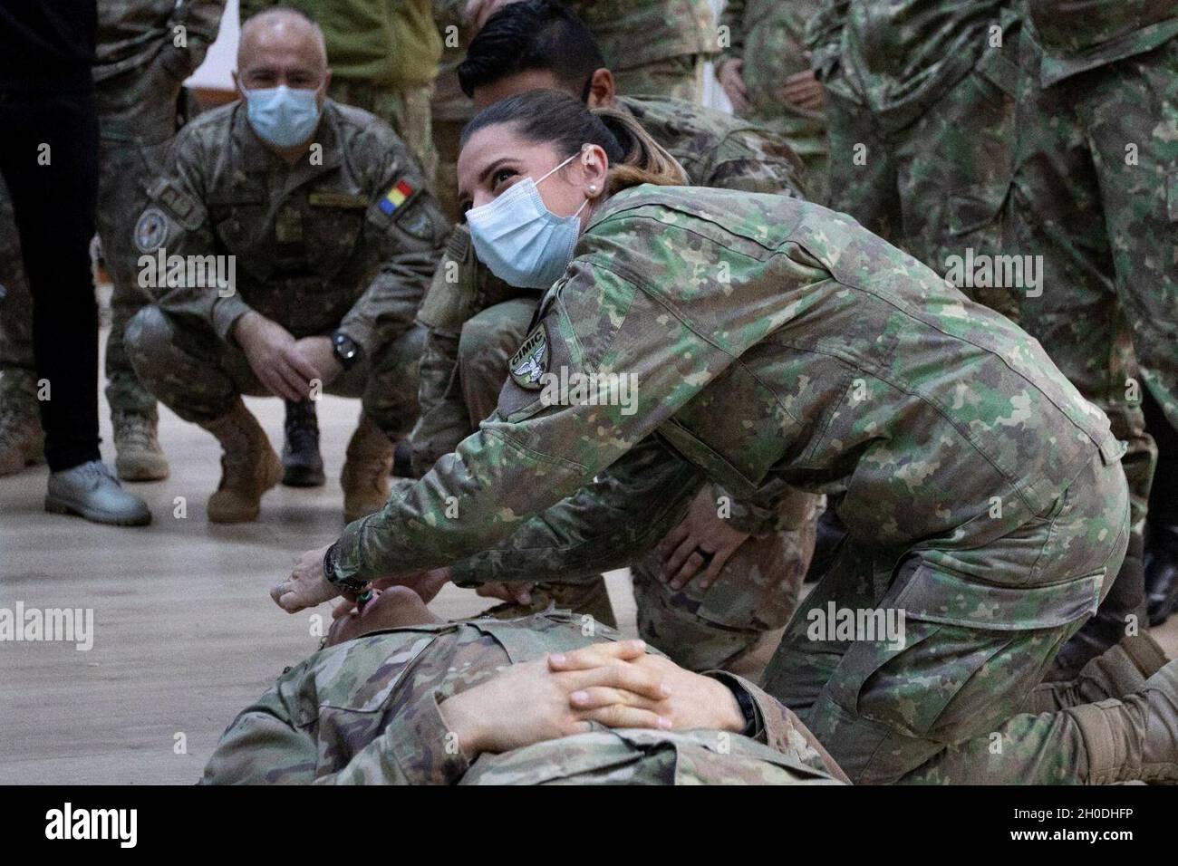 BUCHAREST, Romania – Romanian troops observe a nasal pharyngeal airway application during a combat lifesaver course given here Feb 4. Exchanging lifesaving knowledge and skills enhances interoperability between the two NATO partners and increases readiness within combat environments. Stock Photo