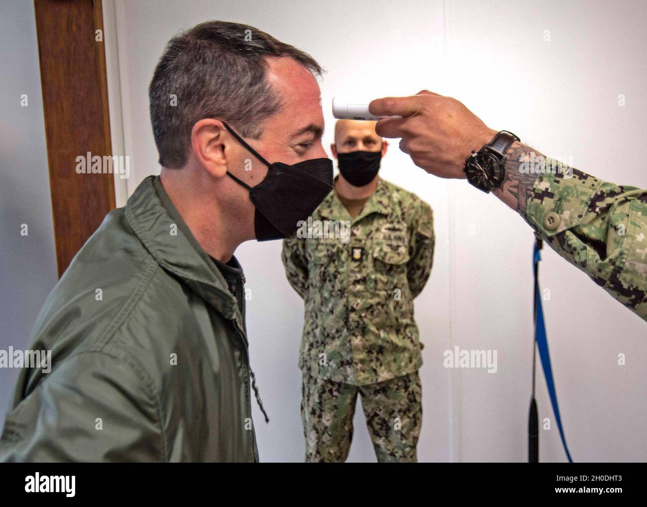 210202-N-NB178-1029 NORFOLK (Feb. 2, 2021) Capt. Todd Marzano, commanding officer of Pre-Commissioning Unit (PCU) John F. Kennedy (CVN 79), gets his temperature checked by the quarterdeck watch at Building U-40 aboard Naval Station Norfolk. PCU John F. Kennedy has been under construction in Newport News since 2015 and is the second aircraft carrier to honor John F. Kennedy for his service to the nation, both as a naval officer and as the 35th President of the United States. Stock Photo