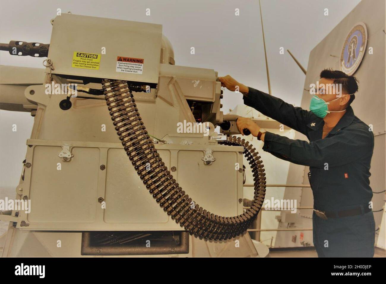 210202-N-BA874-1003 PACIFIC OCEAN (Feb 2, 2021) Gunner’s Mate 2nd Class Gabriel T. Ramos, a native of National City, Calif., conducts pre-fire checks of the MK-38 25 mm machine gun weapon system during a gunnery exercise aboard Arleigh Burke-class destroyer USS Michael Murphy (DDG 112). Michael Murphy is conducting routine operations underway in the U.S. Third Fleet area of operations. Stock Photo