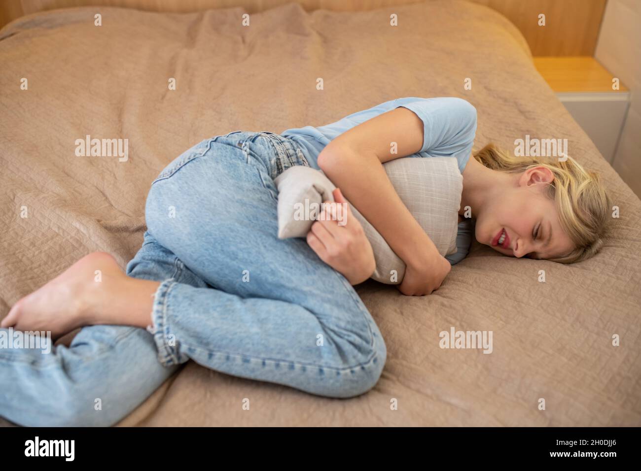 A girl having her critical days and suffering from pain Stock Photo