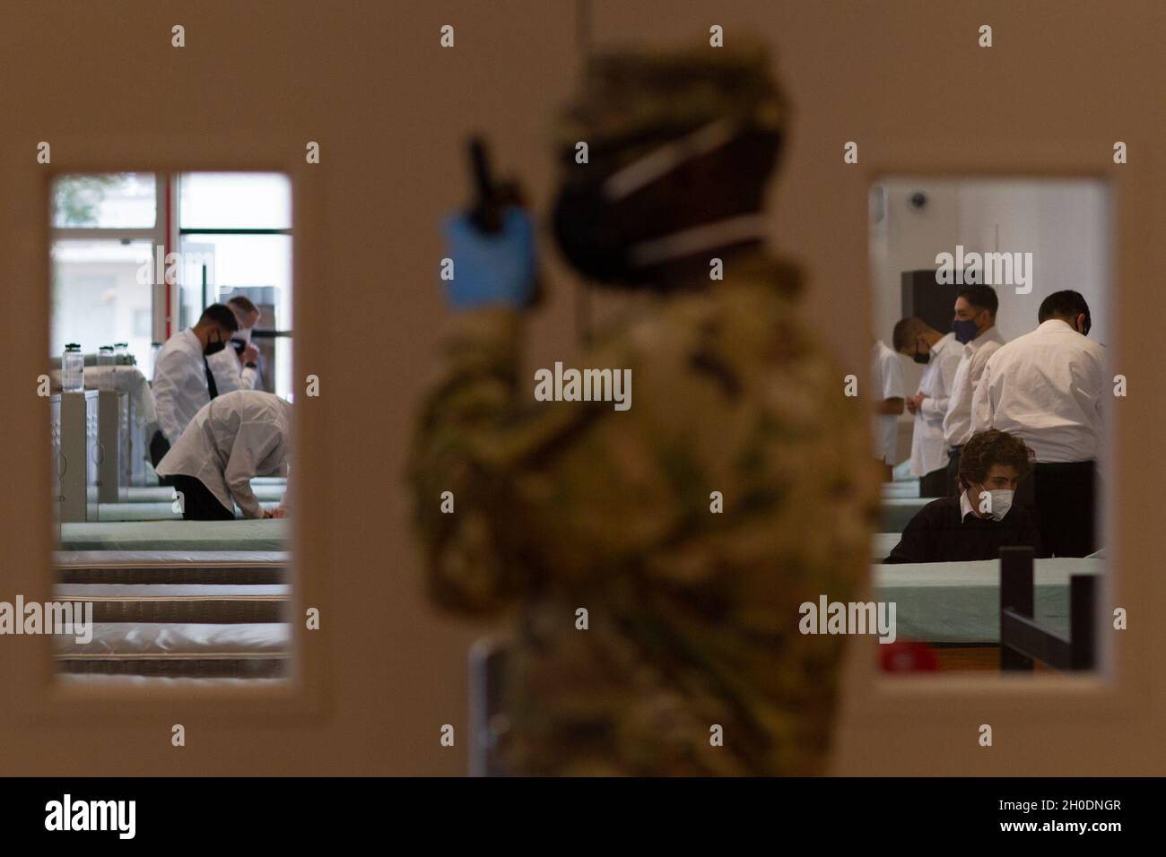 U.S. Army Staff Sgt. Detrick Harris, a California Jobs Challenge platoon  sgt., talks on the radio as his platoon moves into their dorm, Feb. 3,  2021, at Joint Forces Training Base, Los