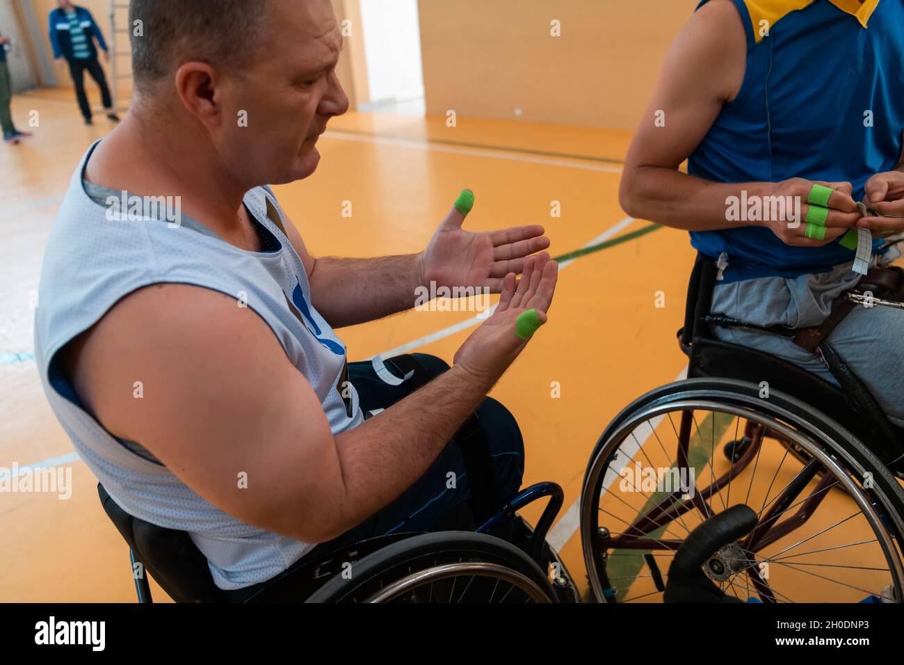 a disabled basketball player puts on a corset and bandages on his arms