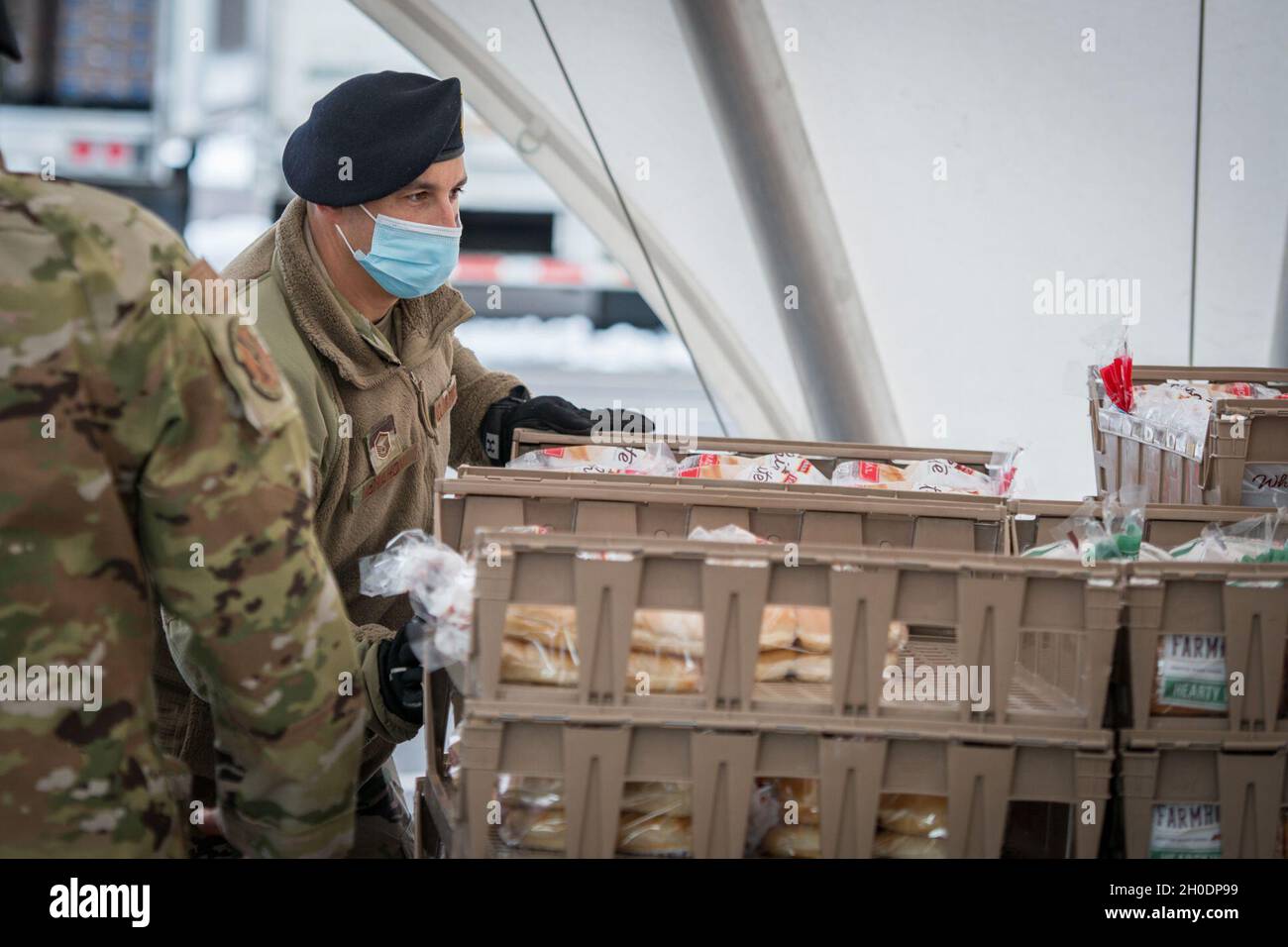 U.S. Air Force Master Sgt. Ian McMahon, 103rd Security Forces Squadron, organizes bread trays for distribution at Rentschler Field in East Hartford, Connecticut, Feb. 4, 2021. Airmen from the Connecticut National Guard’s 103rd Airlift Wing are supporting logistics operations at Foodshare’s drive-thru emergency distribution site here, which has distributed over 8,000,000 pounds of food to 233,000 cars since April 20, 2020. Stock Photo