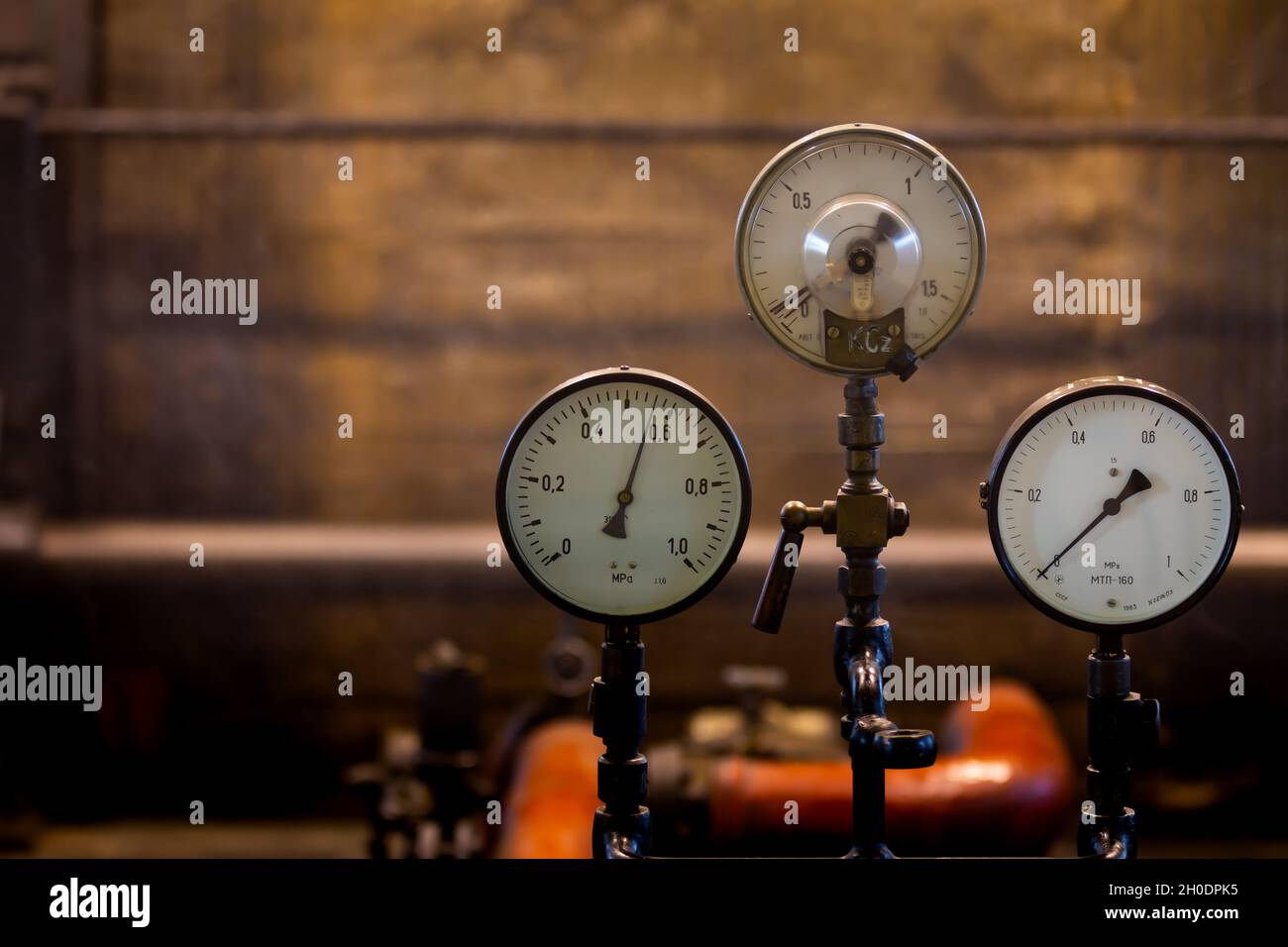 Old analog pressure gauges on an industrial steam plant. Photo taken in low light conditions, natural light Stock Photo