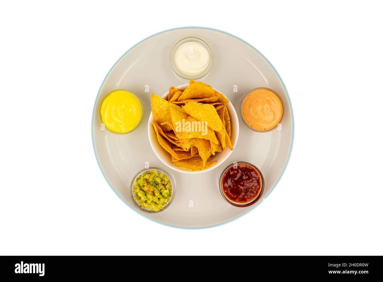 Mexican sauce bowls on a ceramic plate with tortilla chips in the