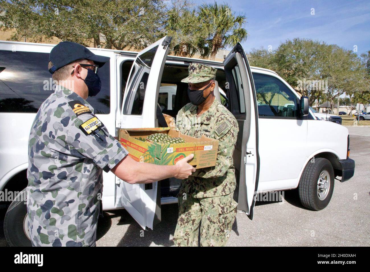 Lt. Matthew McGuire (RAN) and LS1 (EXW) Darrell Moore assist members of a visiting submarine crew with the transfer of provisions at the NAVSUP FLC Jacksonville Logistics Support Center. The visiting submarine is participating in the Diesel-Electric Submarine Initiative (DESI) at Naval Station Mayport. Stock Photo