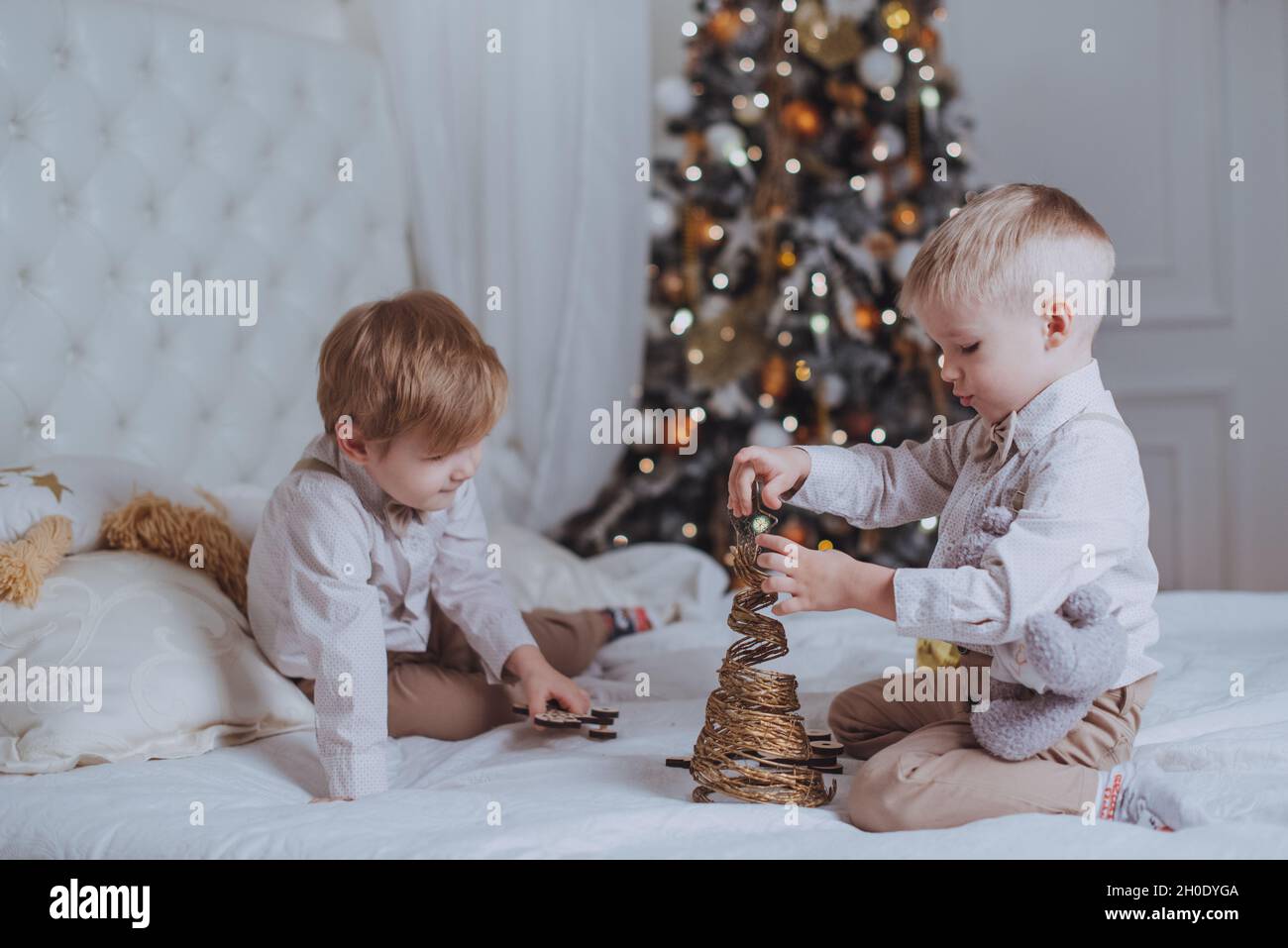 Cheerful cute children boys opening gifts under christmas tree Stock Photo