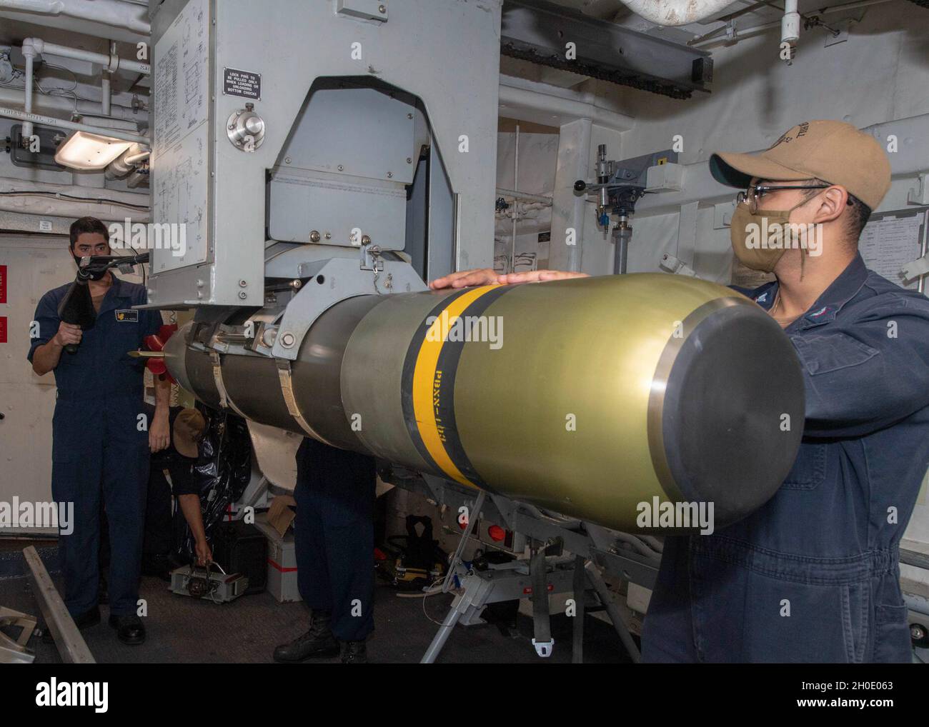 PACIFIC OCEAN (Feb. 5, 2021) U.S. Navy Sonar Technician (Surface) 2nd Class GonzalezPineda, from Victorville, Calif., right, and Sonar Technician (Surface) 3rd Class Jonathan Sherer, from Yucaipa, Calif., move a Mark 46 torpedo aboard the Ticonderoga-class guided-missile cruiser USS Bunker Hill (CG 52) Feb. 5, 2021. Bunker Hill, part of the Theodore Roosevelt Carrier Strike Group, is on a scheduled deployment to the U.S. 7th Fleet area of operations. As the U.S. Navy’s largest forward deployed fleet, with its approximate 50-70 ships and submarines, 140 aircraft, and 20,000 Sailors in the area Stock Photo