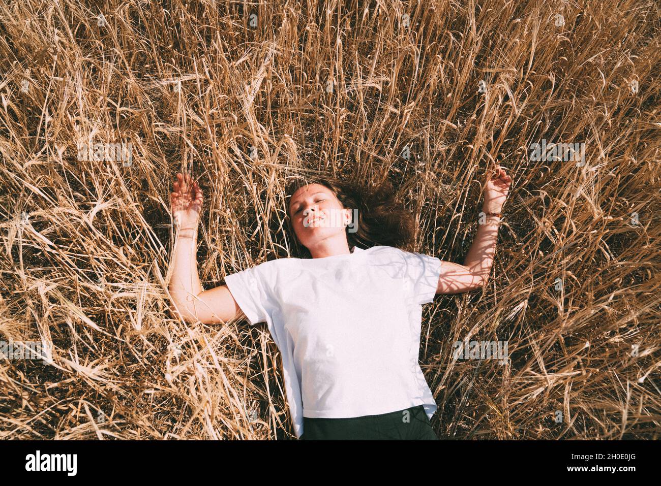 Portrait of a woman lying in a wheat field Stock Photo - Alamy