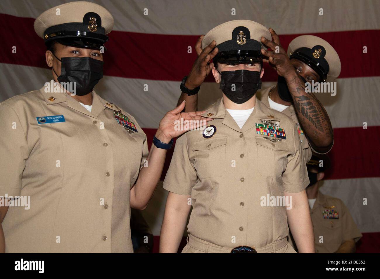 Chief Navy Counselor Gina Hodge, from Lansing, Michigan, assigned to USS Gerald R. Ford’s (CVN 78) administration department, receives her cover during Ford’s chief petty officer pinning ceremony held in Ford's hangar bay Feb. 6, 2021. Twenty-three Ford Sailors were advanced to the rank of chief petty officer. Stock Photo