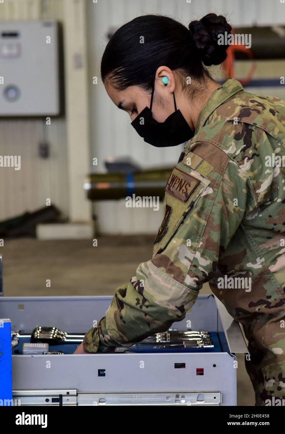 Airman 1st Class Natalie Navia, 35th Aircraft Maintenance Unit weapons load crew member, searches for a tool during the Annual Load Crew Competition at Kunsan Air Base, Republic of Korea, Feb. 6, 2021. Weapons load crews from the 35th Aircraft Maintenance Unit, 80th AMU and 8th Maintenance Squadron were evaluated on how quickly and effectively they could load munitions onto F-16 Fighting Falcons. Stock Photo
