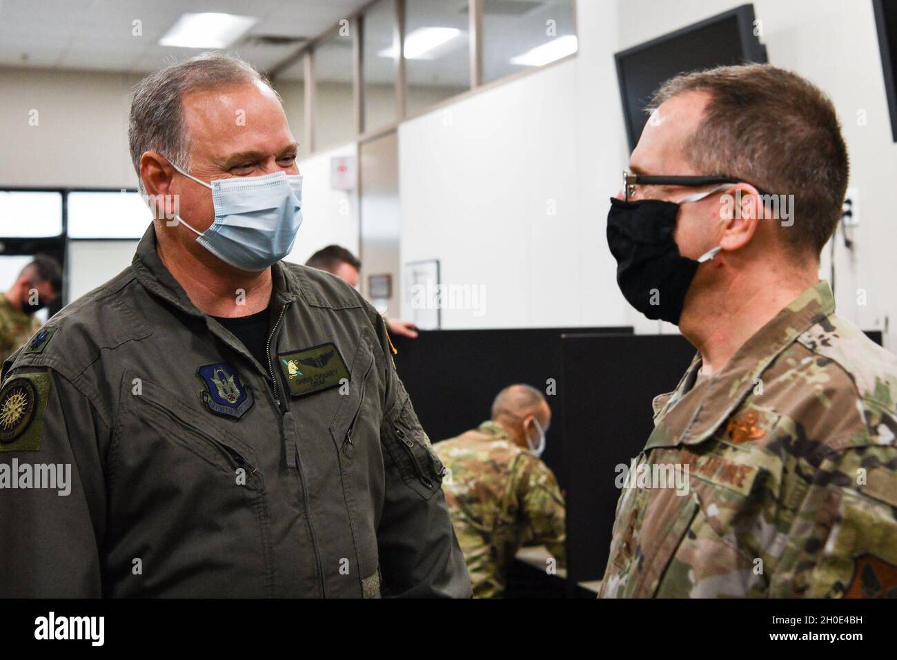 U.S. Air Force Lt. Col. John Cheney, flight surgeon for the 919th Special Operations Medical Squadron, speaks with Lt. Gen. Jim Slife, commander of Air Force Special Operations Command, in the COVID-19 vaccination point of distribution at Duke Field, Florida, Feb. 6, 2021. Personnel from the 919th SOMDS administered a COVID-19 vaccination to Slife during his tour of the facility. Stock Photo