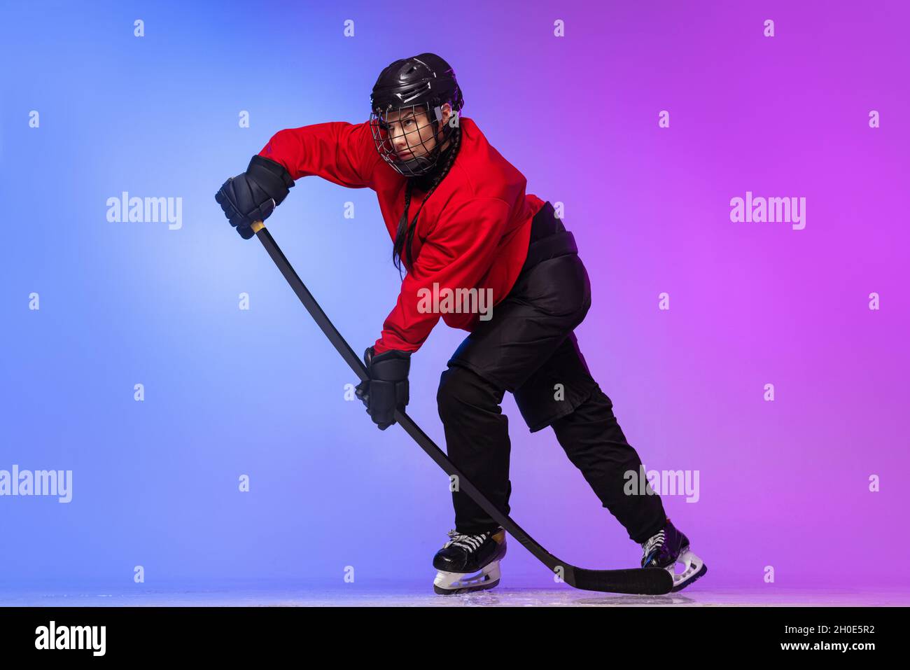 Fulllength portrait of professional female hockey player training