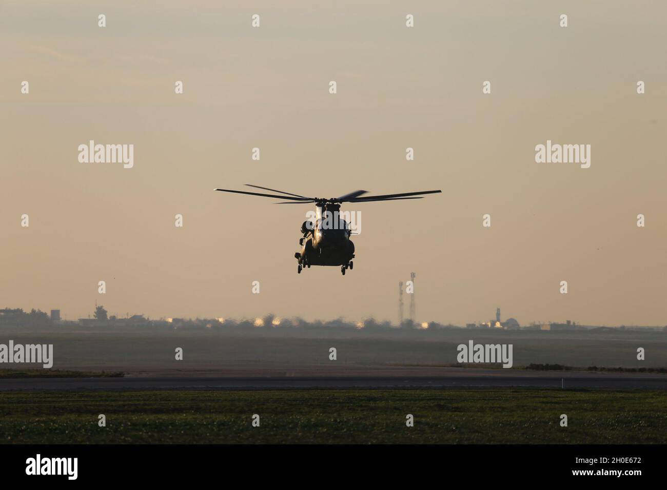 A CH-47 Chinook helicopter, operated by Soldiers with Bravo Company, 3-238th General Support Aviation Battalion, 28th Expeditionary Combat Aviation Brigade, flies over an airfield in the 28th ECAB's area of operations in the Middle East. Stock Photo