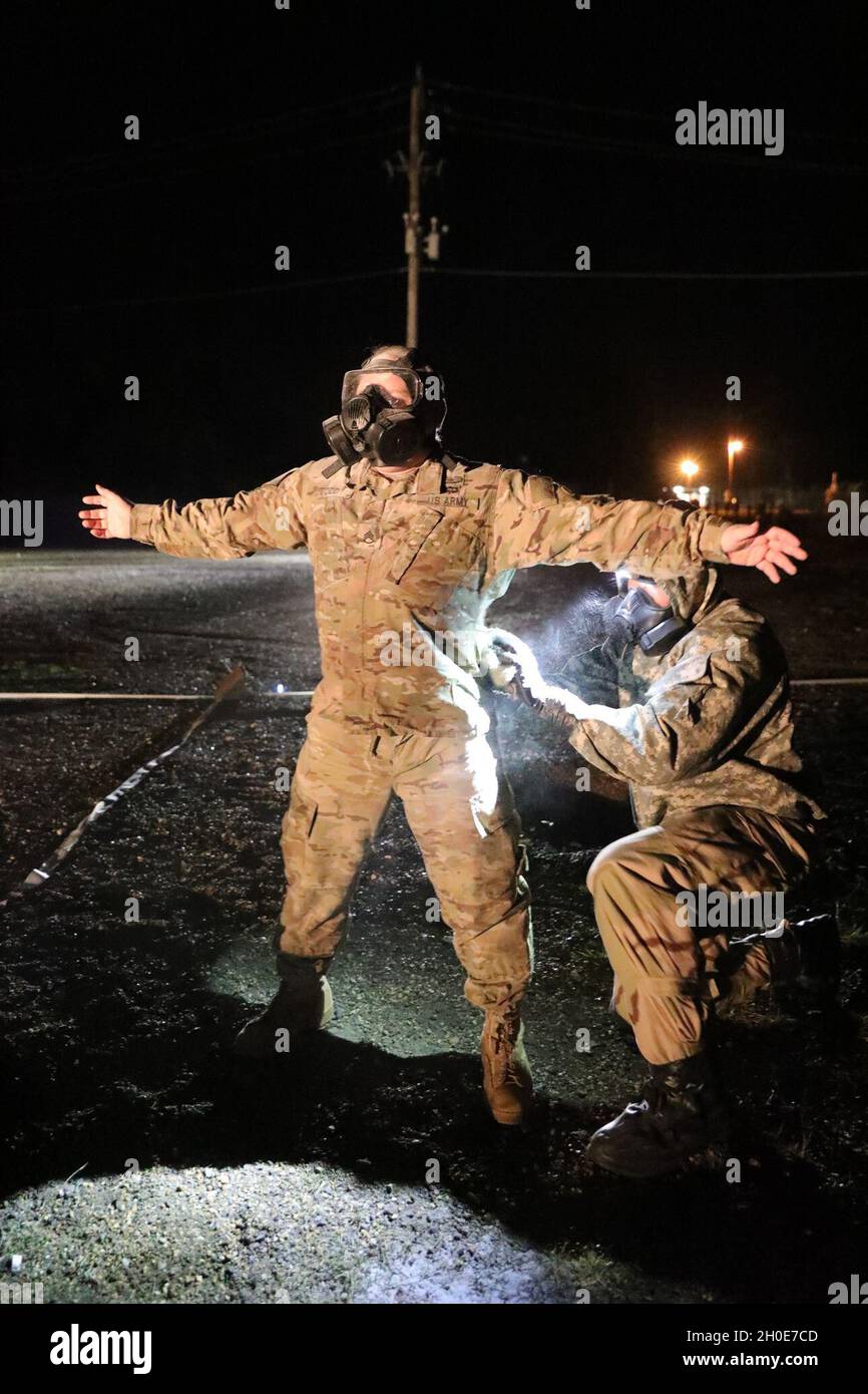 Two Soldiers from Task Force 3330, 3rd Special Forces Group (Airborne),  teach a class on how to properly remove MOPP (Mission-Oriented Protective  Posture) gear in the event of a simulated CBRN (Chemical