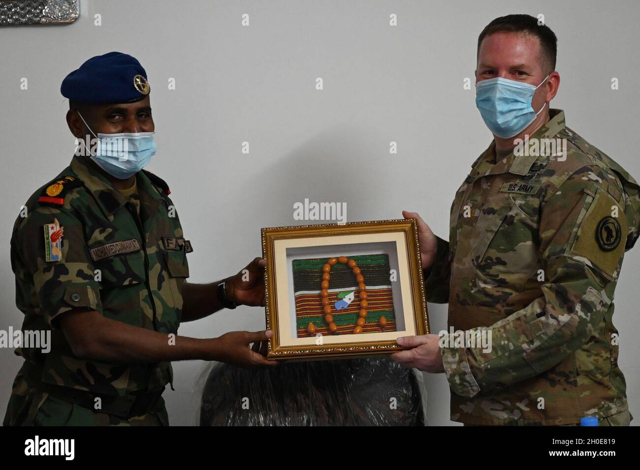 Lt. Col. Mohamed Djama Kyad (left), the Armed Forces of Djibouti (FAD) commander, presents a gift to U.S. Army Maj. Jonathan Holliday (right), Kentucky National Guard Bilateral Affairs Officer, at the FAD military training center at Holhol, Djibouti Feb. 8, 2021. The Kentucky National Guard has been partners with Djibouti since 2015 as part of the State Partners Program (SPP) with the focus to promote mutually-beneficial relationships. Stock Photo