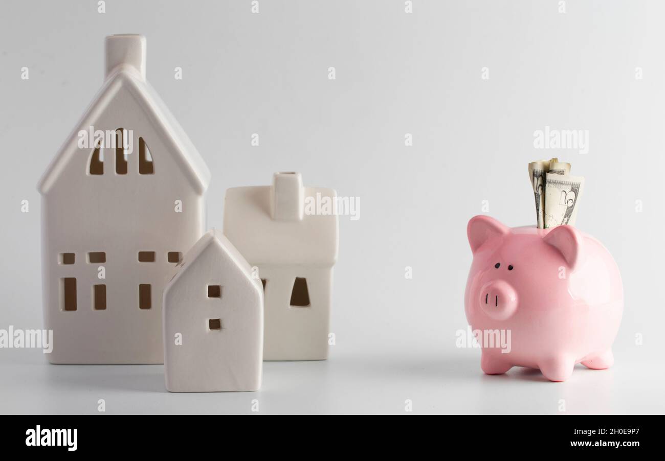 Houses and a Piggy Bank on a White Background Stock Photo