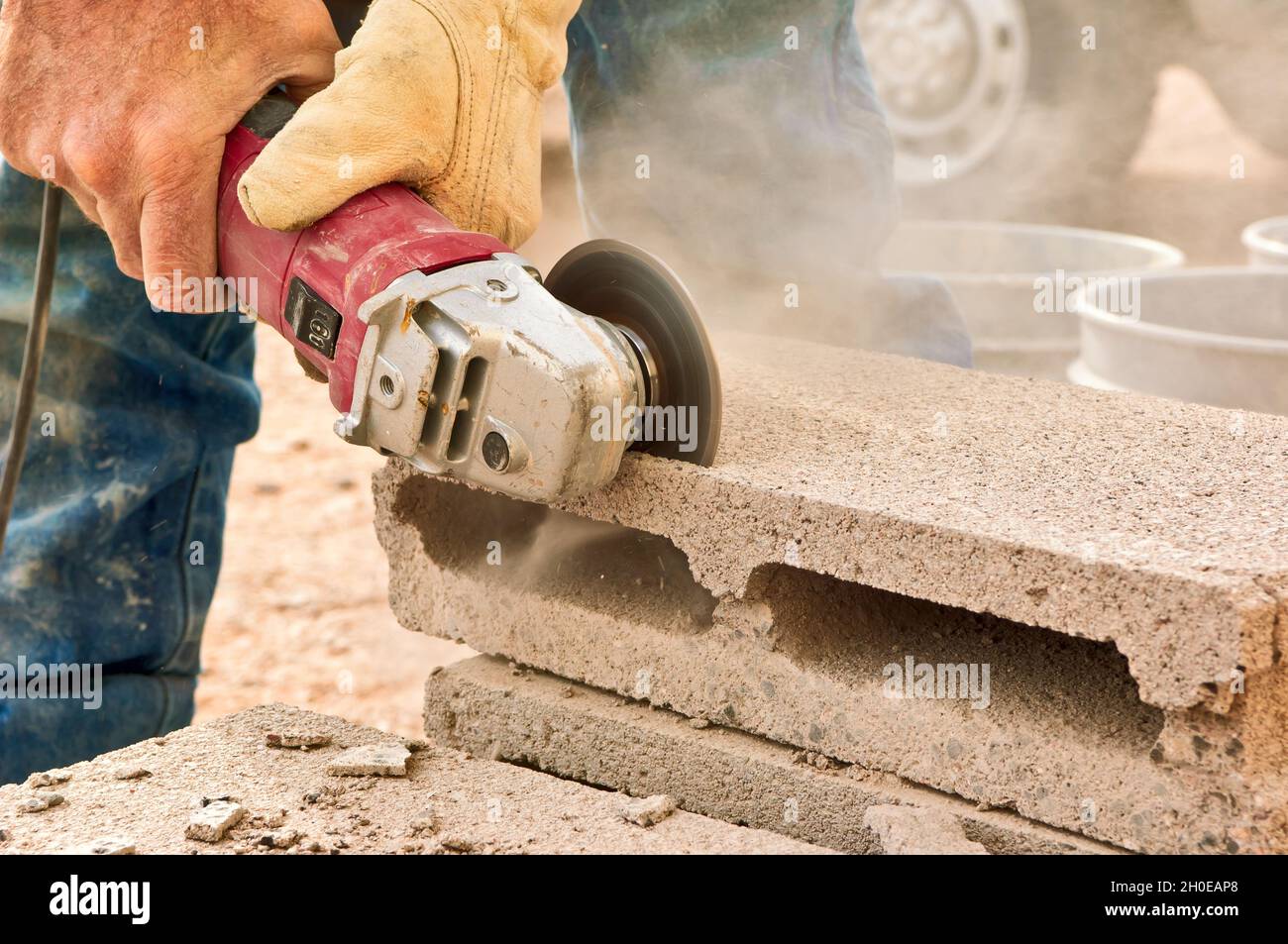 A construction worker's hands guiding an electric grinding tool as he