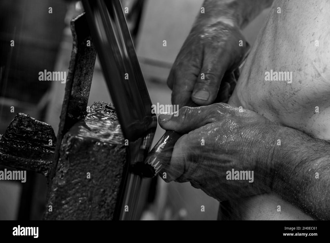A cold worker's hands and during the making of glass beads.this art was inscribed in 2020 on the representative list of the intangible Cultural Herita Stock Photo