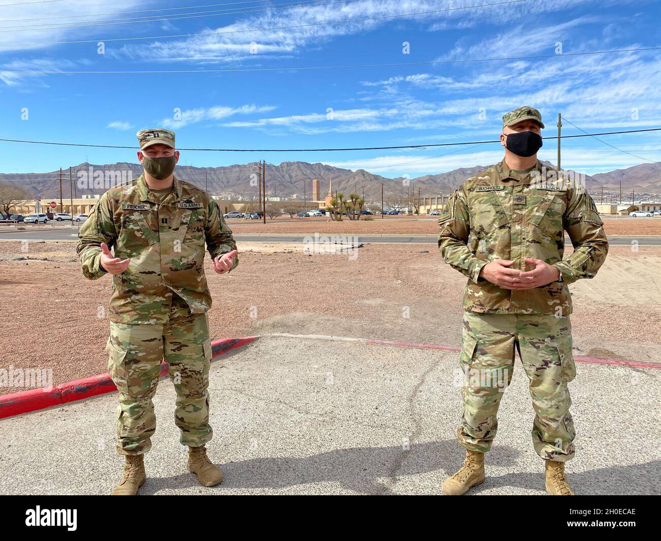 Capt. Mike Poucher (left) from Terry, Montana,  Commander of Detachment 2, of the U.S. Army Reserve's 7407th Troop Medical Clinic, and Staff Sgt. Daniel Buchholtz, a U.S. Army Reserve combat medic from Missoula, Montana, stand in front of a Soldier formation at West Ft. Bliss, Texas in February 2021. Poucher and Buchholtz are two of 35 Army Reserve Medical Command Soldiers from the 7407th Troop Medical Clinic that have mobilized to support COVID-19 isolation and quarantine missions in Texas and New Mexico. Stock Photo