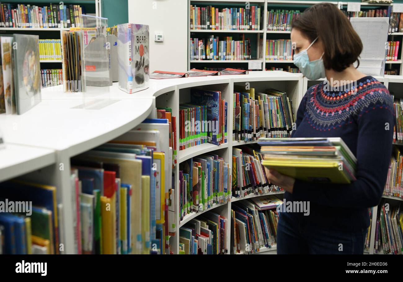 A customer selects books while following Covid19 guidelines at the