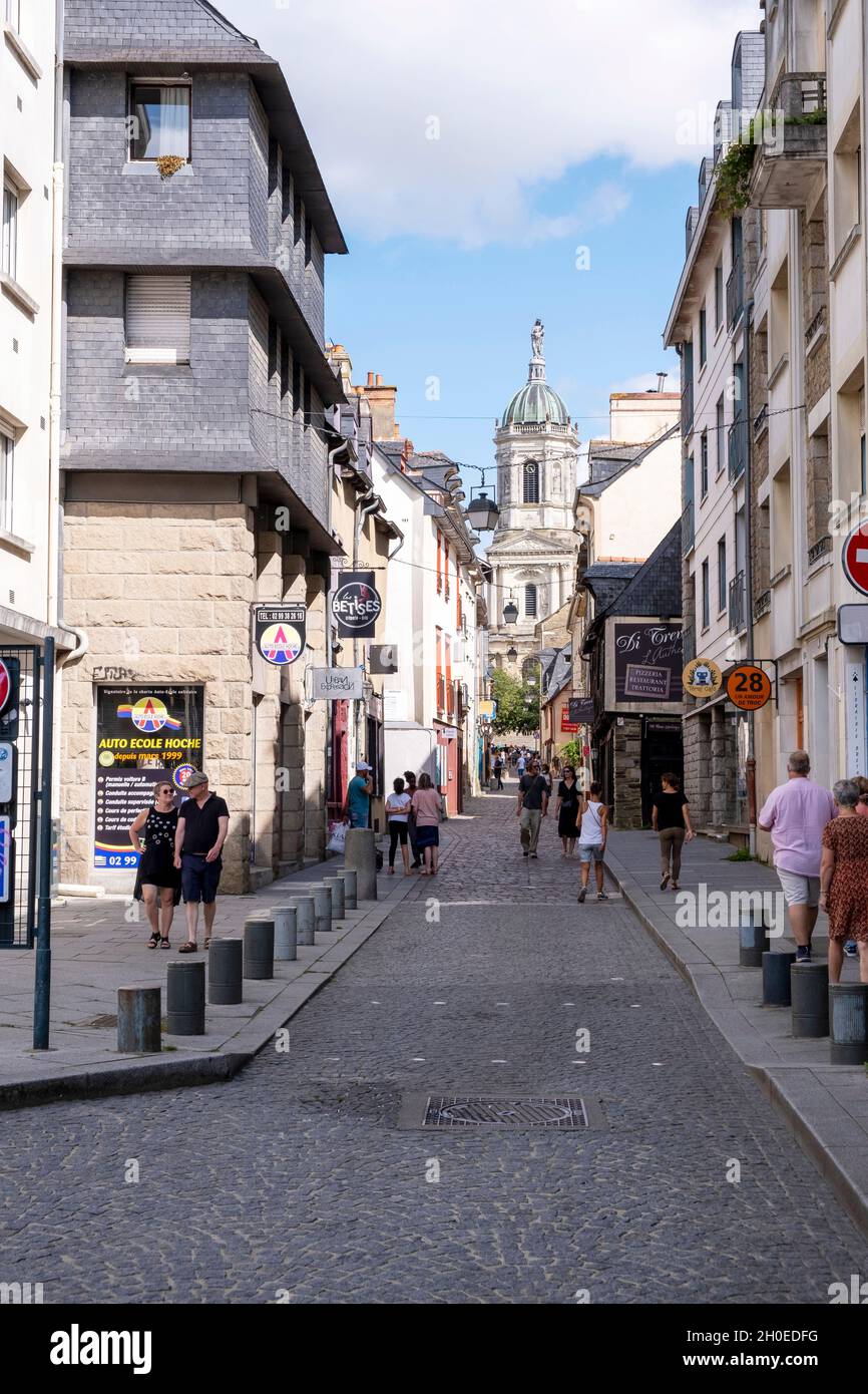 Rennes (Brittany, north western France): pedestrians in “rue Saint Melaine” street, in the city center, and steeple of the Church of Saint Melaine in Stock Photo