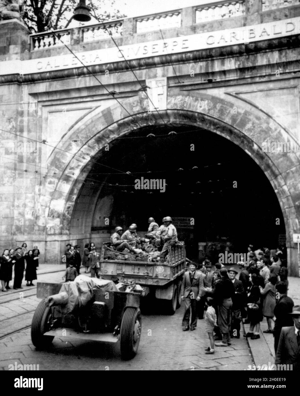 In the newly liberated city of Genoa, Italy, the 92nd Infantry Division troops enter the Galleria Guiseppe Garibaldi, April 27, 1945. Stock Photo