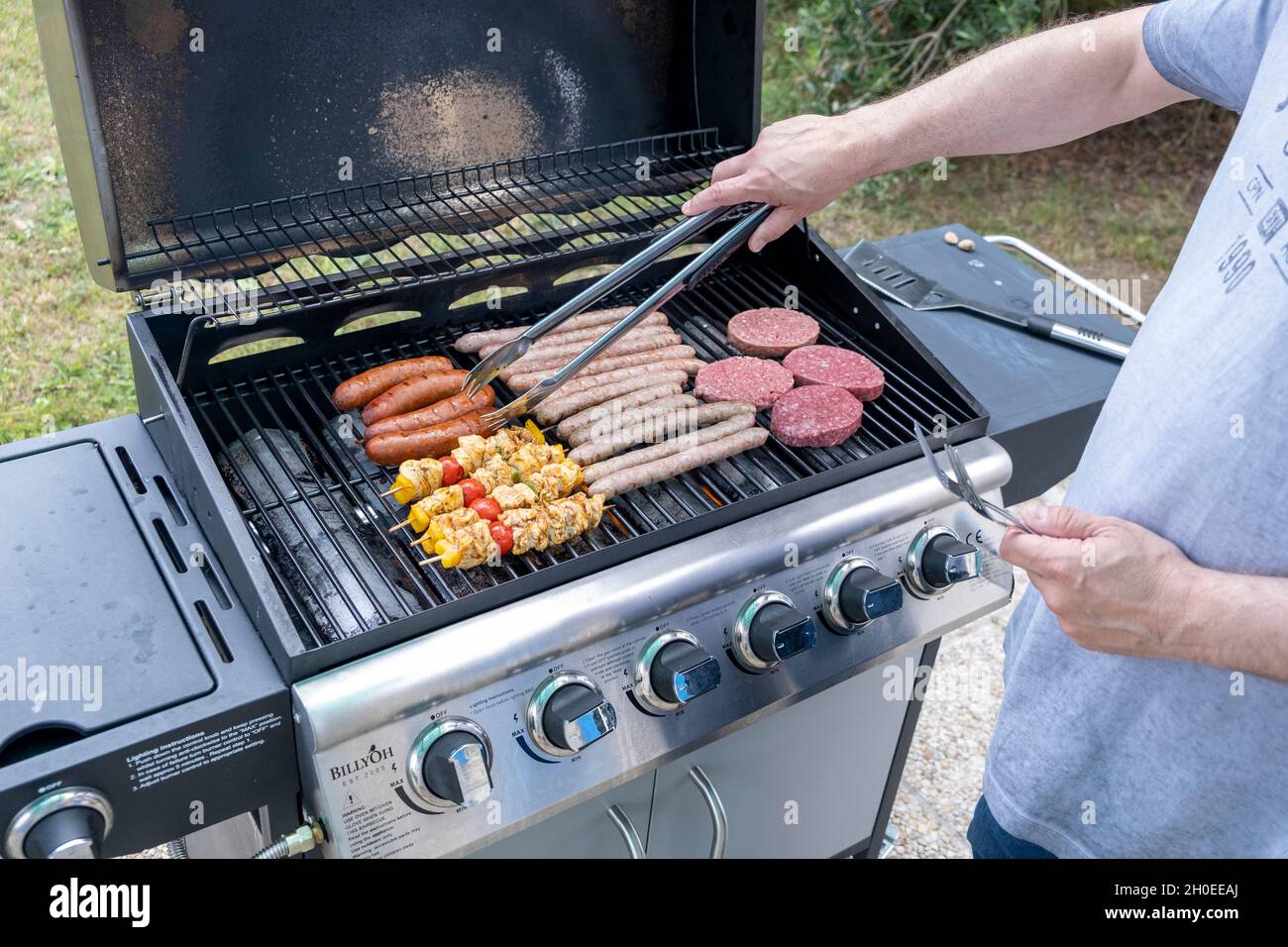 Meat cooked on a gas BBQ, sausages, chipolatas, kebabs and minced beef