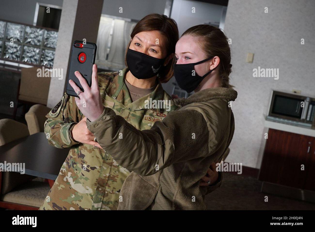 Chief Master Sgt. of the Air Force JoAnne S. Bass, left, takes a selfie with Airman 1st Class Dakota LeGrand following a breakfast panel at Grand Forks Air Force Base, N.D., Feb. 12, 2021. LeGrand was encouraged by Bass to innovate her workplace in order to build up a team who strives to be a part of something bigger than themselves. Stock Photo