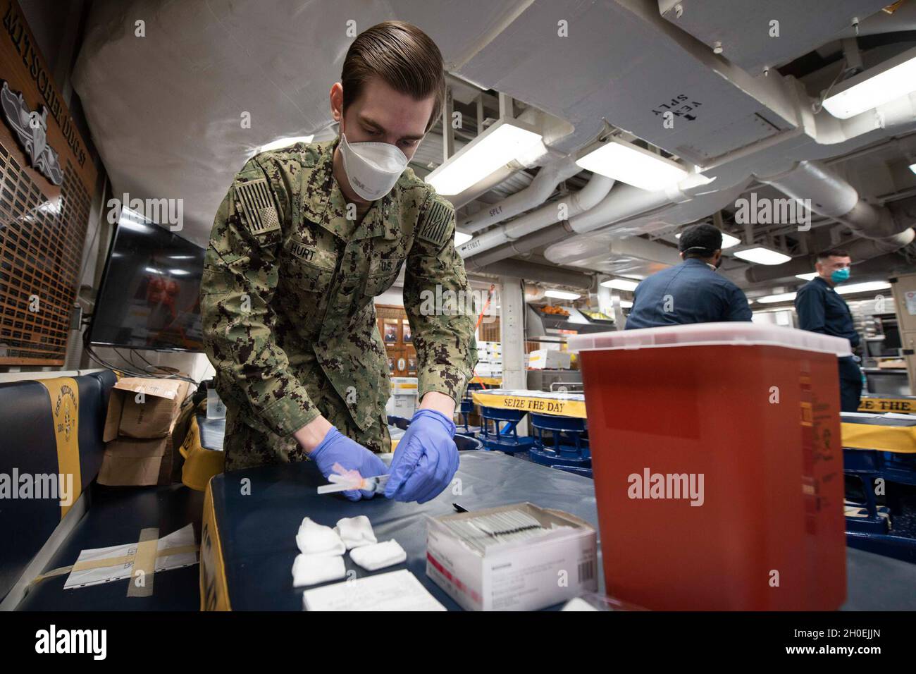 210213-N-QD512-1040 NORFOLK, Va. (Feb. 13, 2020) Hospital Corpsman 3rd Class Austin Hurt, from Las Vegas, prepares COVID-19 vaccinations aboard the Arleigh-Burke class guided-missile destroyer USS Mitscher (DDG 57). Mitscher is currently pier side conducting routine maintenance. Stock Photo