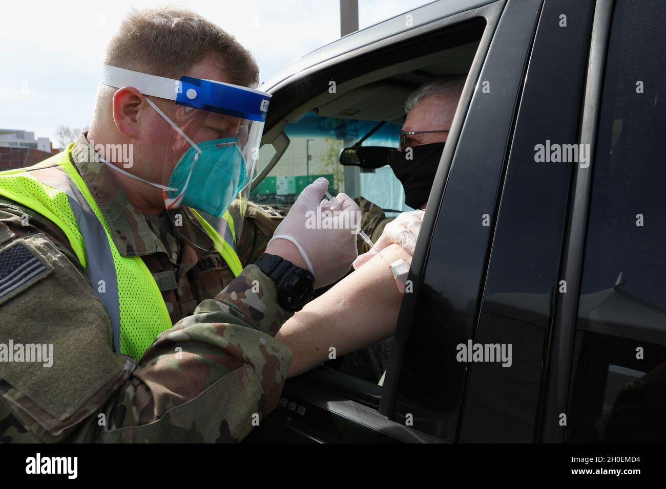 U.S. Army Pfc. William Towne, a combat medic specialist with 4th Battalion, 9th Infantry Regiment, administers a COVD-19 vaccine to a community member at California State University, Los Angeles, Feb. 15, 2021. The site is the first vaccination distribution center operating under a joint effort between federal and state agencies. Stock Photo