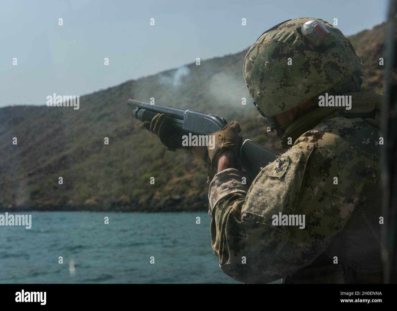 GULF OF TADJOURA, Djibouti (Feb. 16, 2021) A U.S. Navy Sailor assigned to Maritime Security Squadron 8 uses an M500 shotgun to fire an LA-51 off the bow of a patrol boat during live-fire sustainment training conducted in the Gulf of Tadjoura, Feb. 16, 2021. The Maritime Expeditionary Security Force’s primary mission is force protection conducted through fleet support with operations around the world. Stock Photo