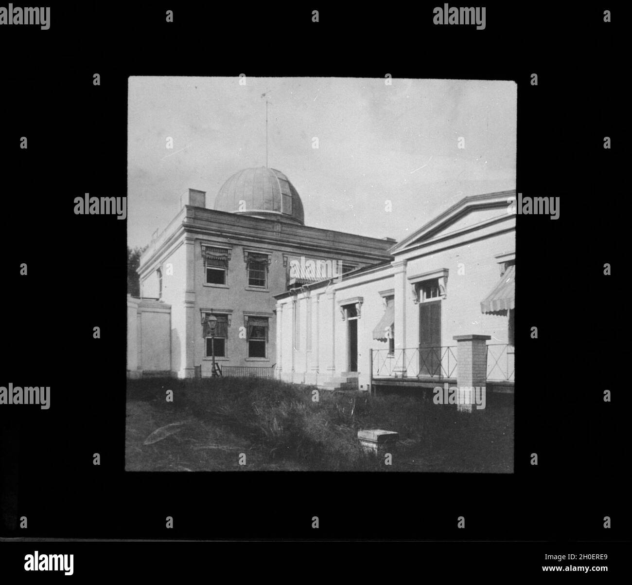 Lantern Slide 50: Old Naval Observatory looking northeast. The time ball* mast can be seen on top of the 9.6-inch refractor dome. *Not used at Obs. After 1884, but at old State, War, & Navy Bldg. The wing to the south (right) housed the prime vertical (lantern slide #137). It also contained a storeroom and, after 1873, office space and the 26-inch refractor. The wing also housed for a time a 6.6-inch refraction circle (1848 – 1861). Photograph about 1888. The Frodsham clock, in the Observatory lobby now, was used in the prime vertical room from about 1850 to 1882 when it was replaced by Howard Stock Photo