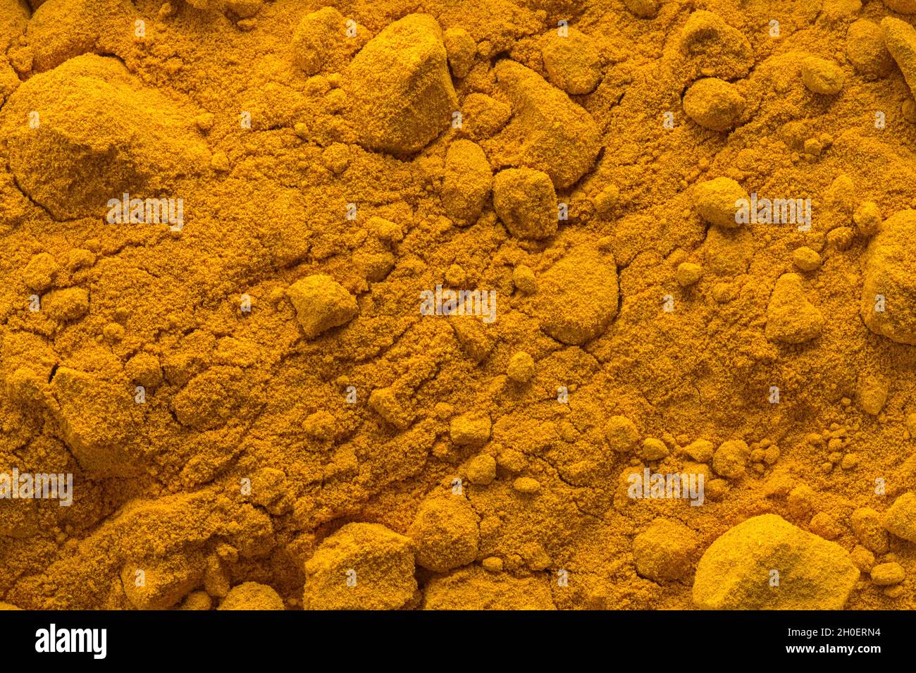 Pile of Turmeric Powder Spice Background Texture. Stock Photo