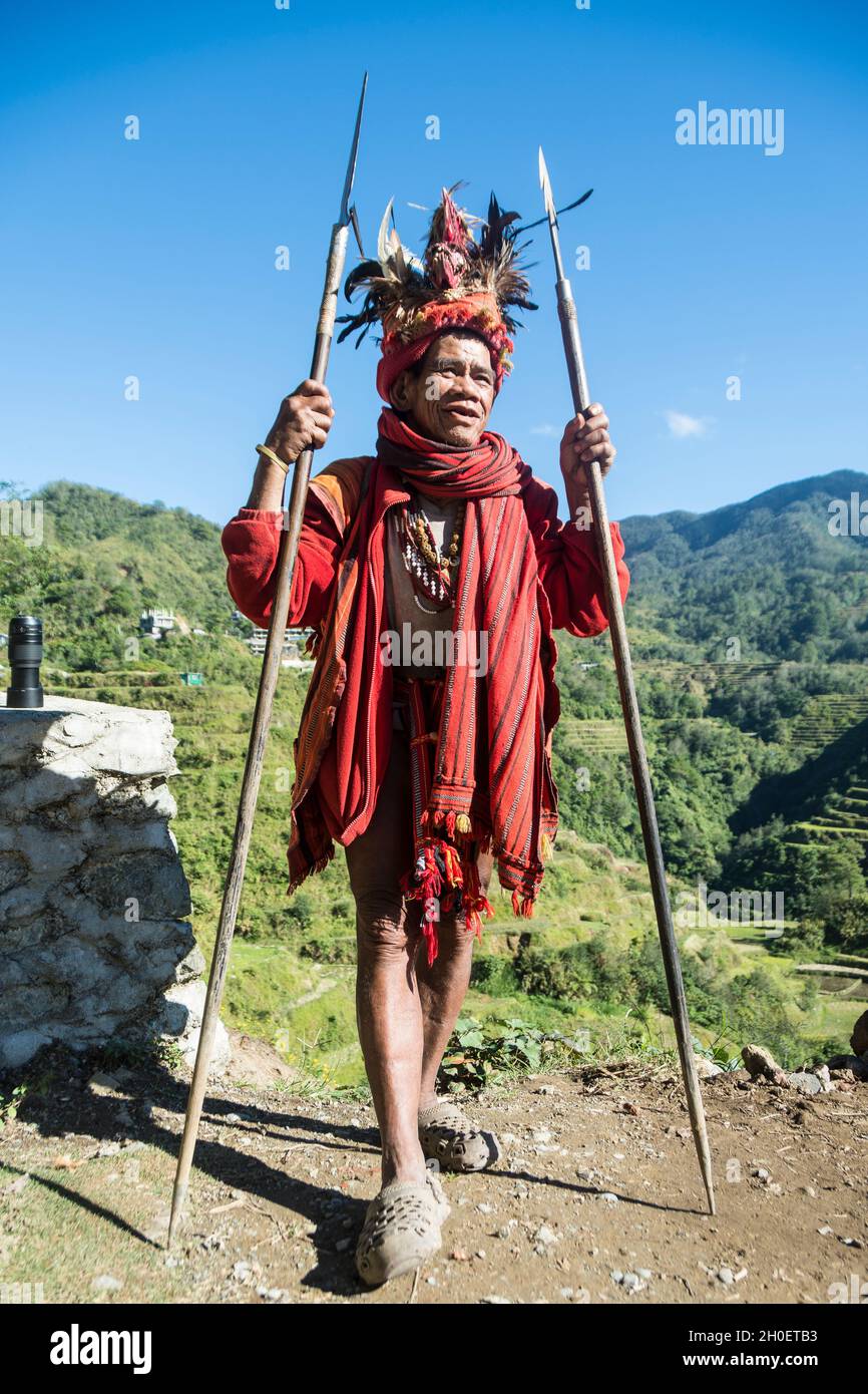 Senior Ifugao man in traditional costume. Banaue Rice Terraces in the background. Banaue, Ifugao province, Philippines Stock Photo