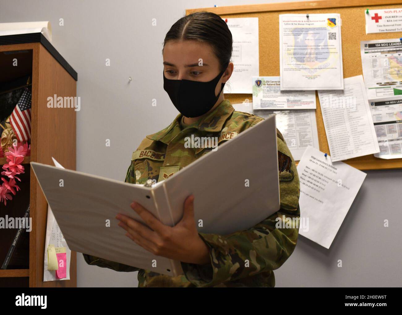 Senior Airman Weronika Baczek, public health technician, 104th Medical Group, views a binder, in her office at Barnes Air National Guard Base, Massachusetts, Feb. 17, 2021. Contact tracing is critical for safeguarding 104th Fighter Wing mission readiness and the health of our Barnestormers and surrounding communities from COVID-19. Stock Photo