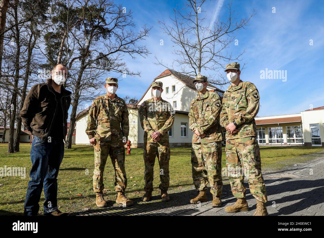 (From left to right) Joachim Strauch, a German who was treated by American Soldiers after being involved in a car crash, stands next to his rescuers; Maj. Benjamin Stork, Chief Warrant Officer 2 Robert Riedel, Sgt. Patrick Carter, and Spc. Bruce Cook, assigned to Bravo Company, 6th General Support Aviation Battalion, 101st Combat Aviation Brigade, during an awards ceremony recognizing the team for their efforts, Grafenwoehr, Germany, Feb. 18, 2021. Brig. Gen. Christopher Norrie, Commander, 7th Army Training Command, and Brig. Gen. Thomas Hambach, Commander, Landeskommando Bayern, were both pre Stock Photo