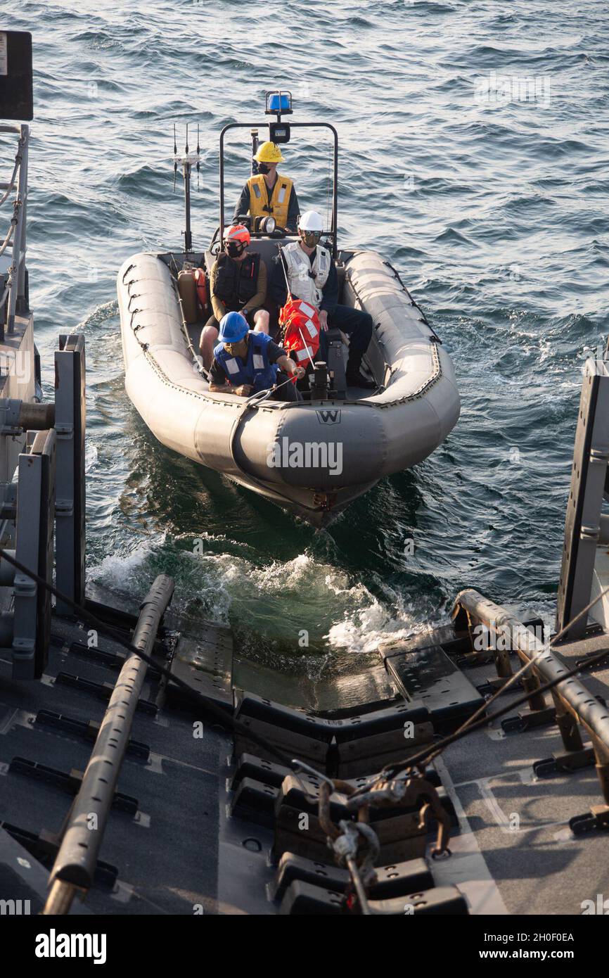 210218-A-BD272-0388 GULF OF OMAN (Feb. 18, 2021) – Sailors assigned to patrol coastal  ship USS Chinook (PC 9) launch a rigid-hull inflatable boat during small boat operations in the  Gulf of Oman, Feb. 18. Chinook is deployed to the U.S. 5th Fleet area of operations in support  of naval operations to ensure maritime stability and security in the Central Region, connecting  the Mediterranean and Pacific through the western Indian Ocean and three strategic choke  points. Stock Photo