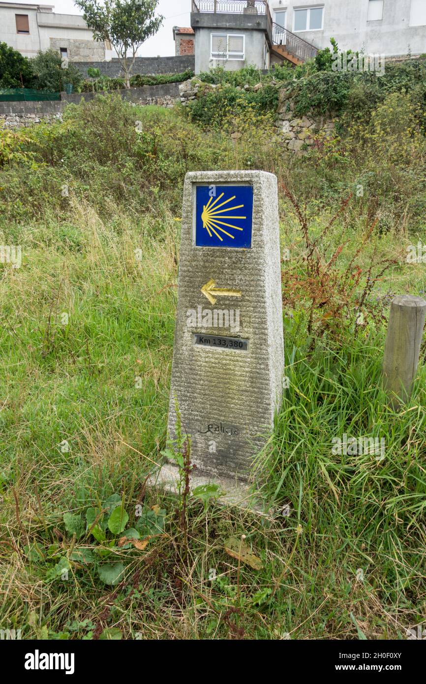 Stone pillar sign Way of St James, direction Camino de Santiago, Christian Pilgrimage route, Galicia, Spain. Stock Photo