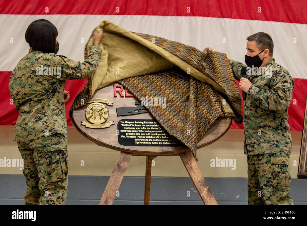 U.S. Marine Corps Lt. Col. NaTasha Everly, left, commanding officer, and Chief Warrant Officer 4 Eric M. Brown, an infantry weapons officer, both with Weapons Training Battalion (WTBN), Marine Corps Installations East-Marine Corps Base Camp Lejeune, unveil the Redfield plaque during a ceremony to establish the call word 'Redfield' for the battalion firing desk on Stone Bay, North Carolina, Feb. 19, 2021. WTBN specializes in marksmanship, selecting the Redfield 3x9x40 scope for its significant historical impacts like it being used by Sgt. Charles 'Chuck' Mawhinney, who holds the Corps' record f Stock Photo