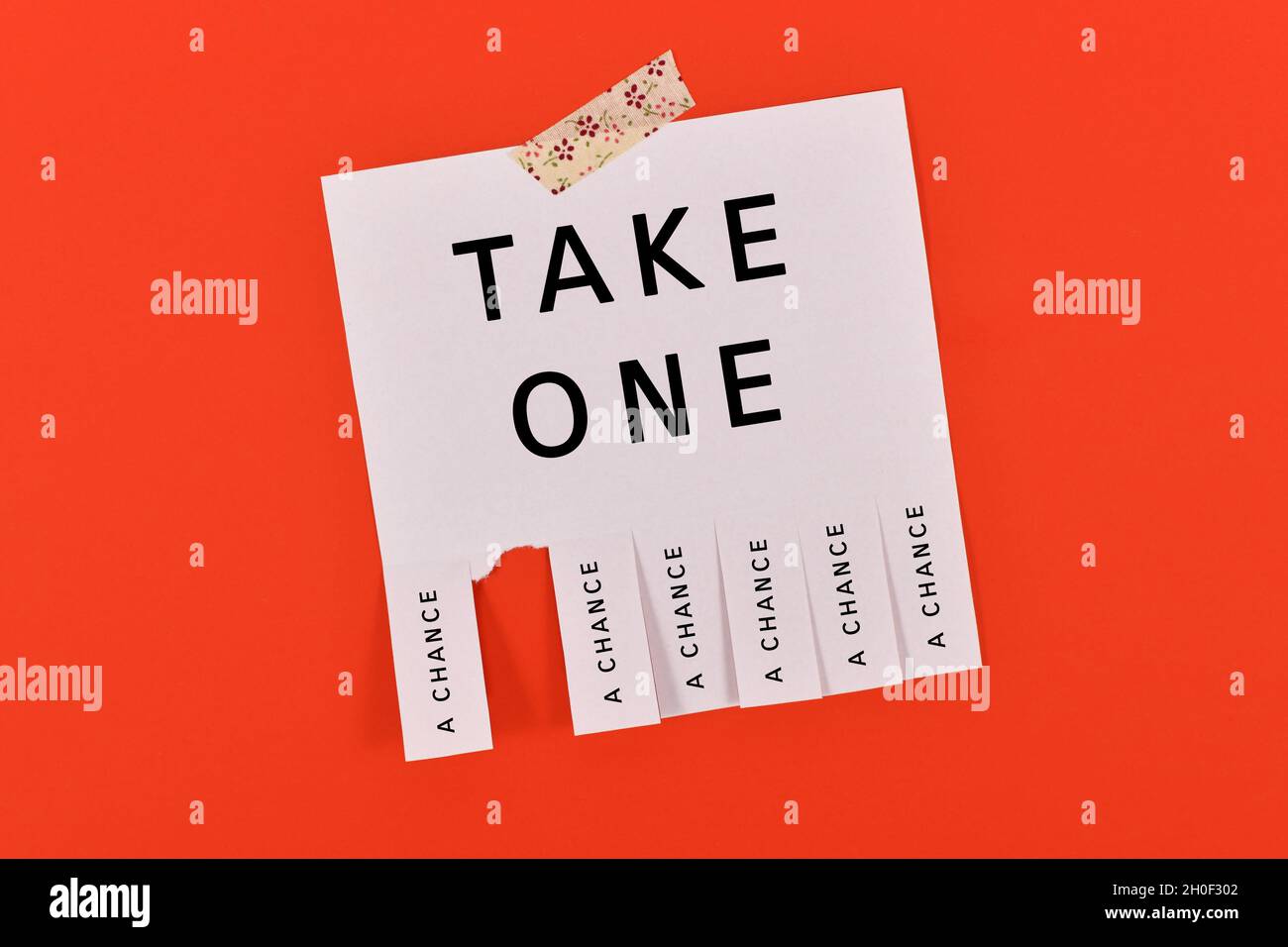 Tearoff stub note with text 'Take a chance' on red background Stock