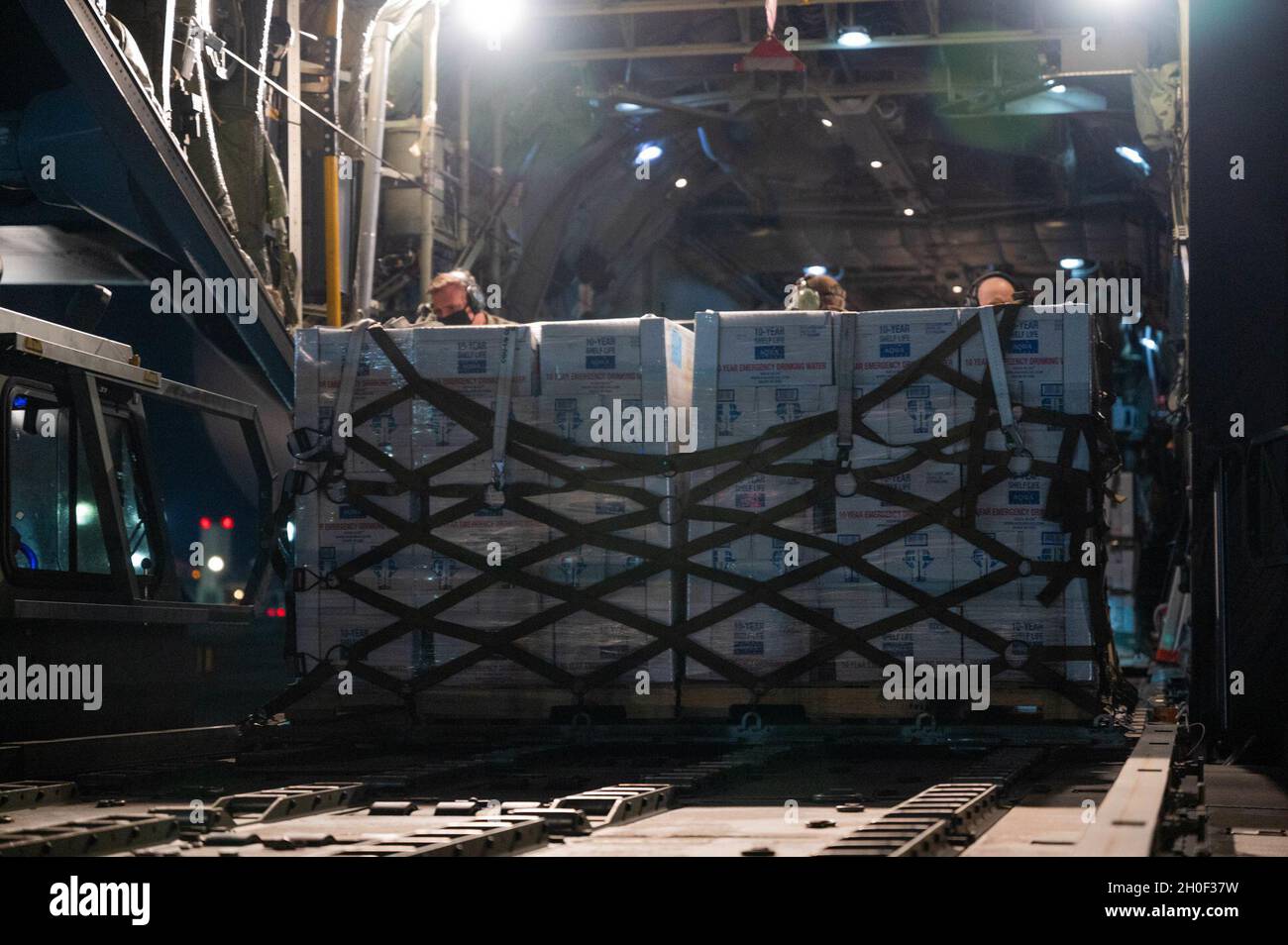 Texas Air National Guardsmen work to unload pallets of water from a C-130H Hercules February 20, 2021, at Laughlin Air Force Base, Texas. The aircraft delivered emergency bottled water to Del Rio, Texas in response to a water shortage caused by Winter Storm Uri. Stock Photo
