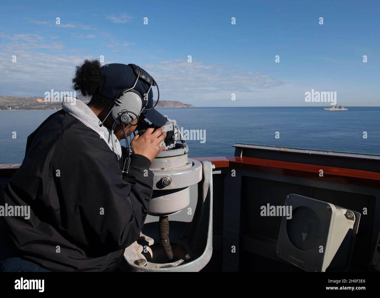 210220-N-RG171-0118 SOUDA BAY, Greece (Feb. 20, 2021) Quartermaster Seaman Apprentice Aaliyah McBride looks through a telescopic alidade as the Arleigh Burke-class guided-missile destroyer USS Donald Cook (DDG 75) departs Souda Bay, Greece, Feb. 20, 2021. Donald Cook, forward-deployed to Rota, Spain, is on patrol in the U.S. Sixth Fleet area of operations in support of regional allies and partners and U.S. national security in Europe and Africa. Stock Photo
