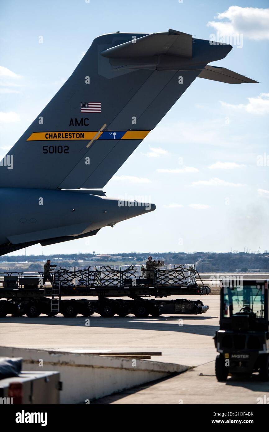 U.S. Air Force Airmen with the 502nd Logistics Readiness Squadron transport pallets of bottled water, Feb. 21, 2021, at Joint Base San Antonio-Kelly Field, Texas. The 502LRS assisted with the coordinating and unloading of approximately 80,000 bottles of water brought in via aircraft at Kelly Field to be distributed to the city of San Antonio following Winter Storm Uri. Stock Photo