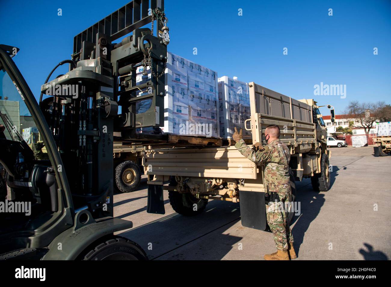 U.S. Air Force Tech. Sgt. Jesse Farmer, 502nd Logistics Readiness Squadron non-commissioned officer in charge, assists with the transportation of pallets of bottled water, Feb. 21, 2021, at Joint Base San Antonio-Kelly Field, Texas. The 502LRS assisted with the coordinating and unloading of approximately 80,000 bottles of water brought in via aircraft at Kelly Field to be distributed to the city of San Antonio following Winter Storm Uri. Stock Photo
