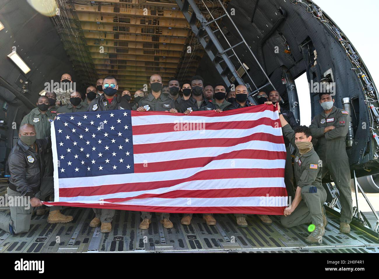 U.S. Airmen pose for a group photo in a C-5M Super Galaxy Feb. 19, 2021, at Travis Air Force Base, California. Twenty-seven crew members flew a heritage flight, honoring Black service members and aviators. Stock Photo