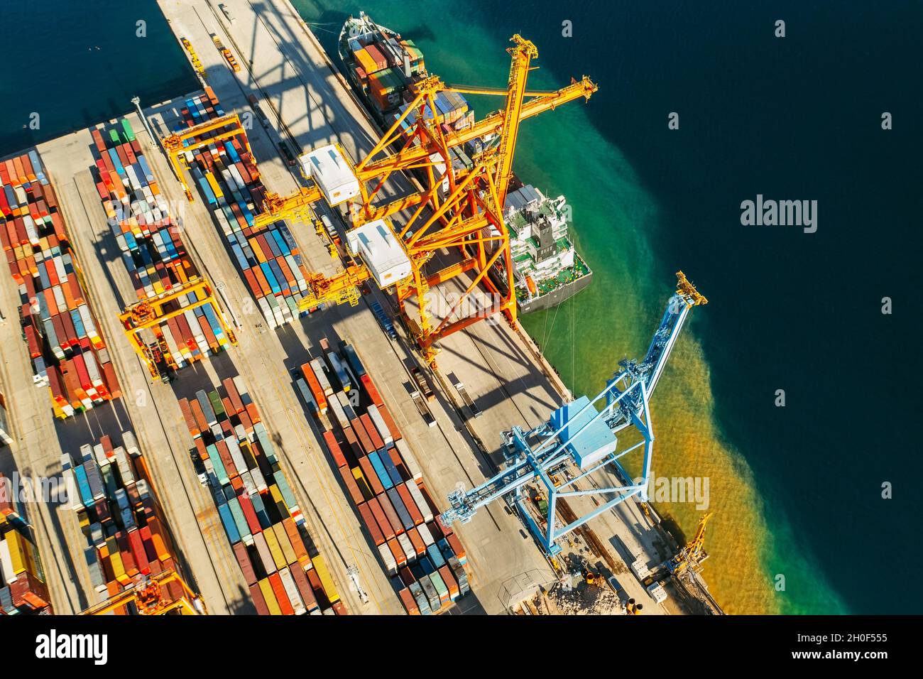 Containers in international shipping dock waiting to import or export and transportation. Top view of loading containers on the ship in the port Stock Photo