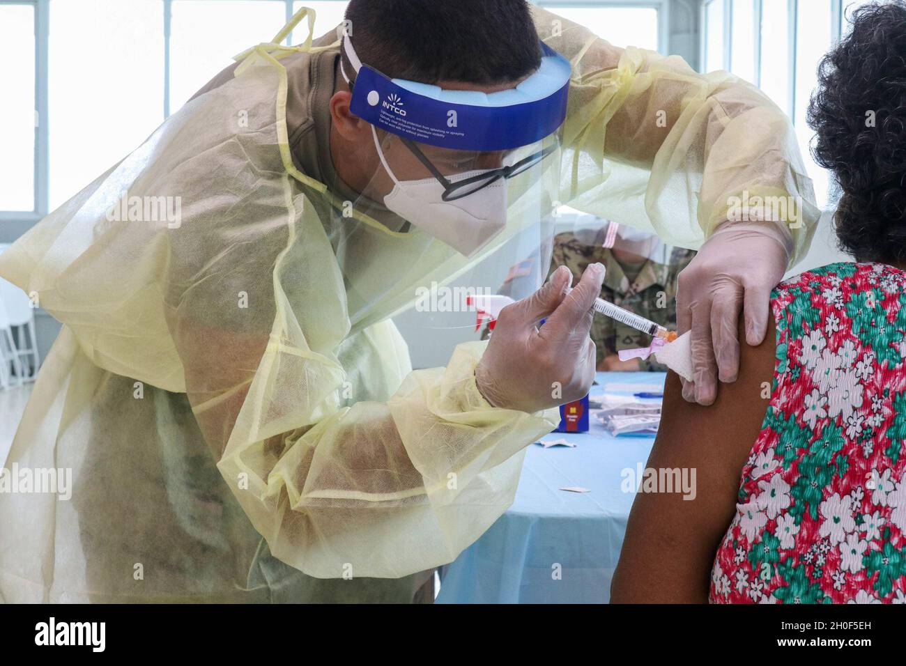 Pvt. Joe Díaz, a medic from the Joint Task Force Puerto Rico applies a COVID-19 vaccine at 'Jardines de la Nueva Puerta' in Rio Piedras, Puerto Rico, Feb. 22, 2021. The commitment from the Puerto Rico National Guard to vaccinate against the COVID-19 does not stop until reach all population of the island. Stock Photo