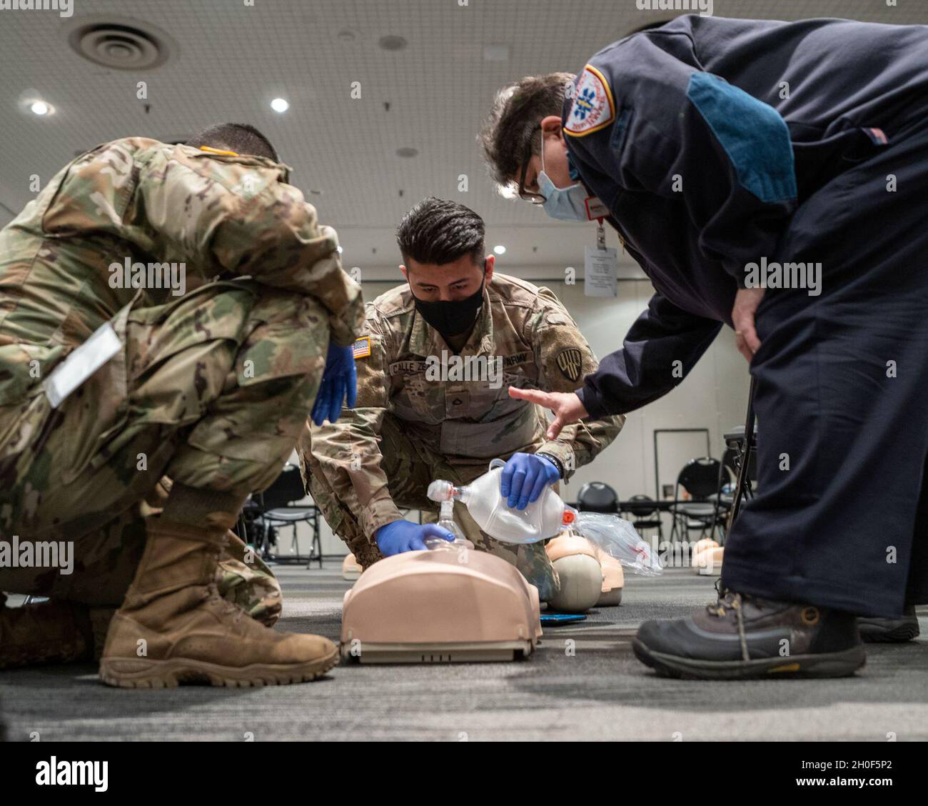 U.S. Army Pfc. Gean Pierre Balvin and Pfc. Franciso Calle Zeas, assigned to the 133rd Composite Support Company, 369th Sustainment Brigade, 53rd Troop Command, are guided by instructor Maria Figueroa, as they receive a class on Cardiopulmonary resuscitation, which is an emergency procedure that combines chest compressions often with artificial ventilation to manually preserve intact brain function until further measures are taken to restore spontaneous blood circulation and breathing in a person who is in cardiac arrest, from Empress Emergency Medical Services, in support of state efforts to p Stock Photo